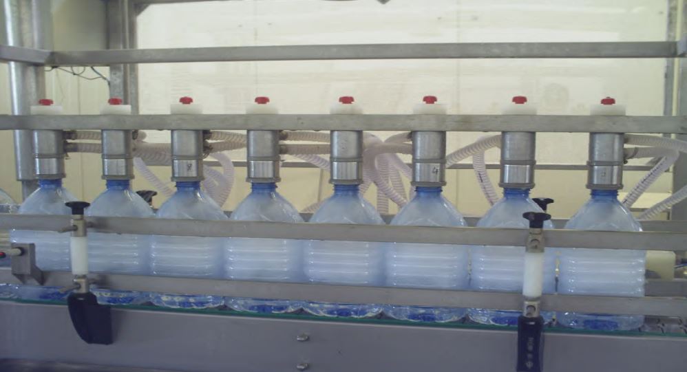 Des bidons de 5L sous une remplisseuse automatique a 8 tetes - SAGIREM